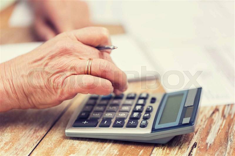 Business, savings, annuity insurance, age and people concept - senior woman with calculator and papers counting at home, stock photo