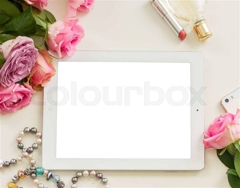 Styled flat desktop scene with white tablet, mobile and rose flowers, stock photo