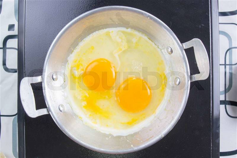 Fried egg in pan / cooking egg pan concept, stock photo
