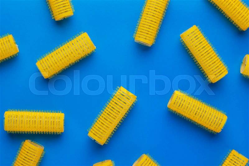 Yellow hair curlers on the blue background, stock photo