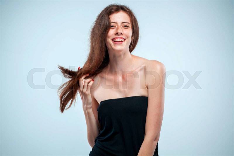 The young woman\'s portrait with happy emotions on gray background, stock photo