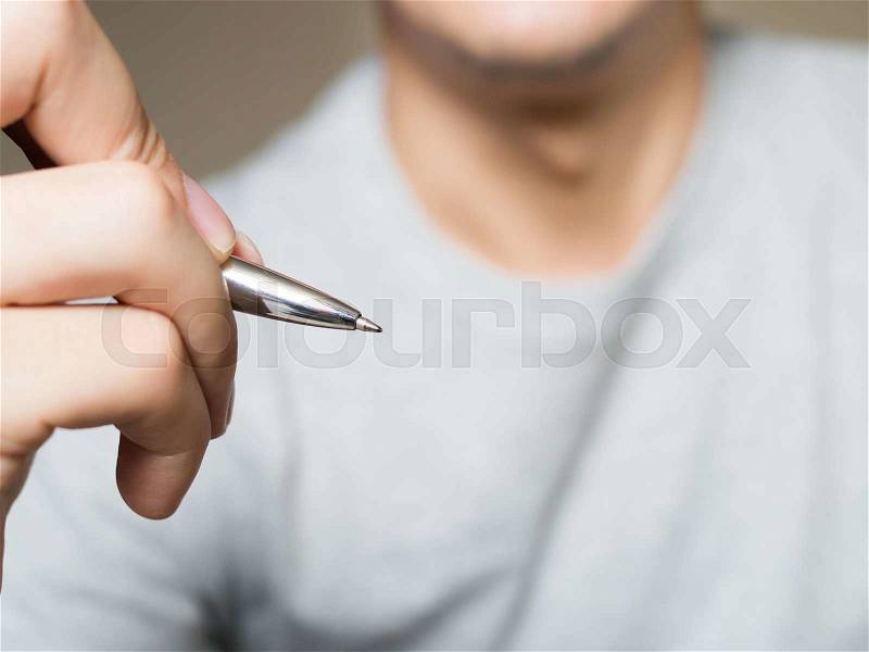 Man holding pen, writing and drawing in the air with copy space, stock photo