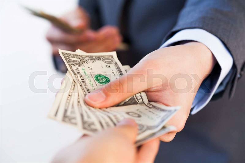 Business man giving bank notes to another person. Corruption and Payment concept, stock photo