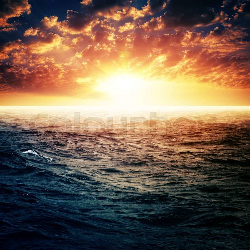 Dramatic sunset over ocean surface, abstract summer vacation backgrounds, stock photo