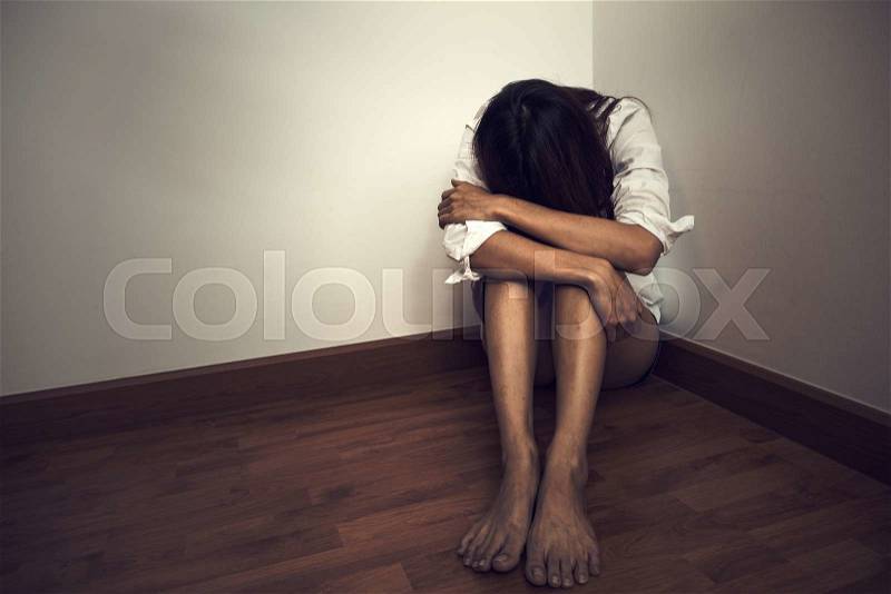 Sad woman sitting alone in a empty room (Vintage color), stock photo