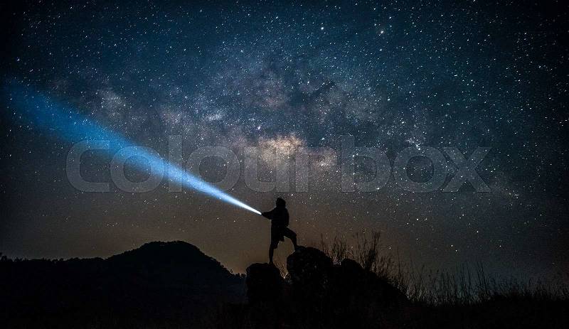 Star-catcher. A person is standing next to the Milky Way galaxy , stock photo