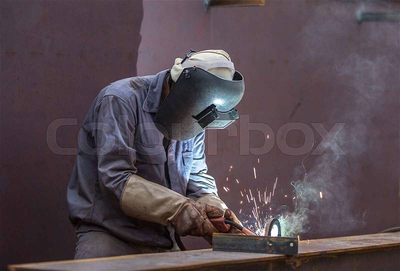 Worker with protective mask welding metal, stock photo