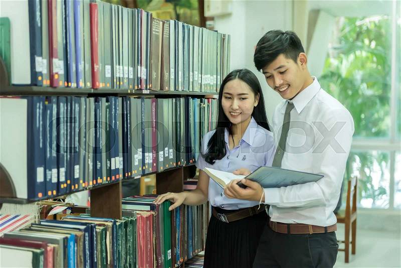 Students studying together in the library at the university, stock photo