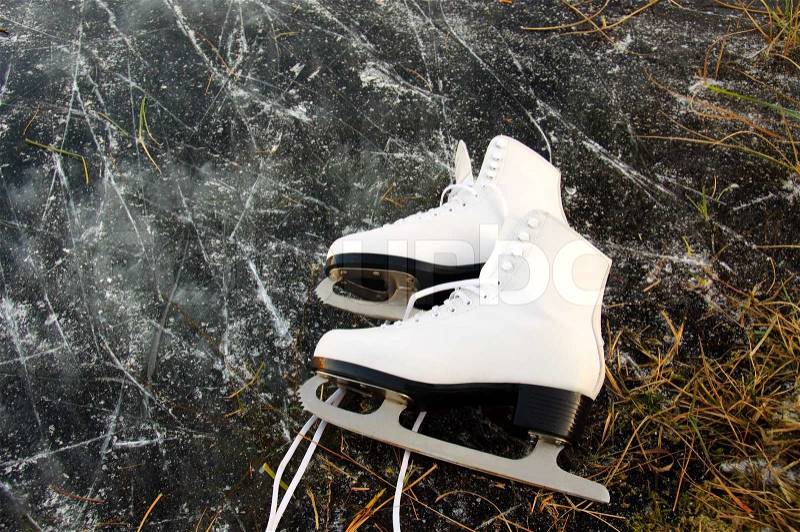A pair of female figure skates lying on the ice, stock photo