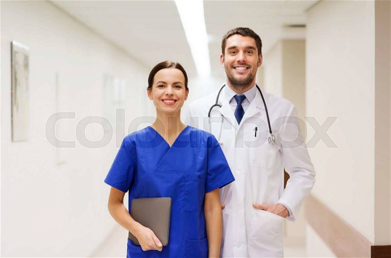 Healthcare, profession, people and medicine concept - smiling doctor in white coat and nurse with tablet pc computer at hospital, stock photo