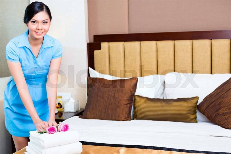 Chambermaid cleaning in Asian hotel room, stock photo