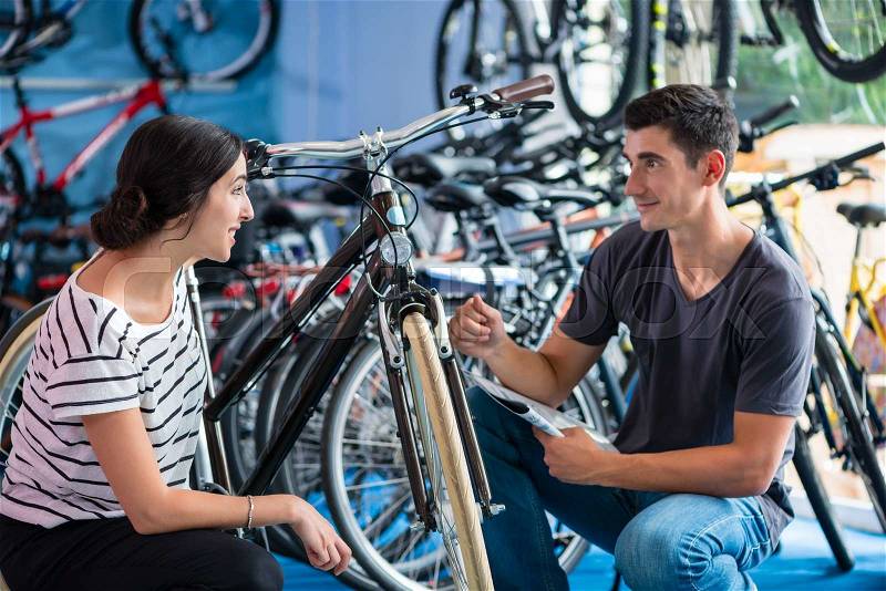 Couple looking for bicycle in bike shop, stock photo