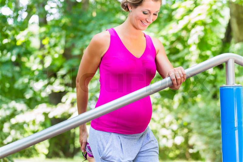 Pregnant woman doing pregnancy exercises on Fitness-Trail, stock photo