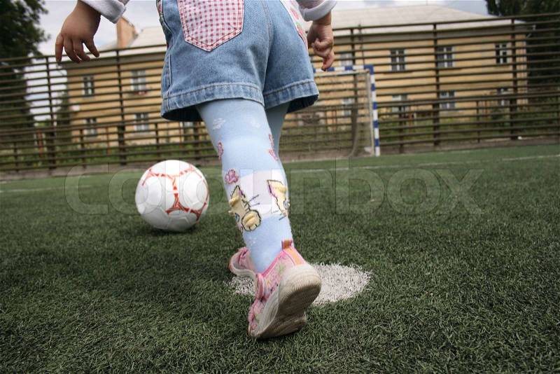 The child with a ball runs to a gate, stock photo