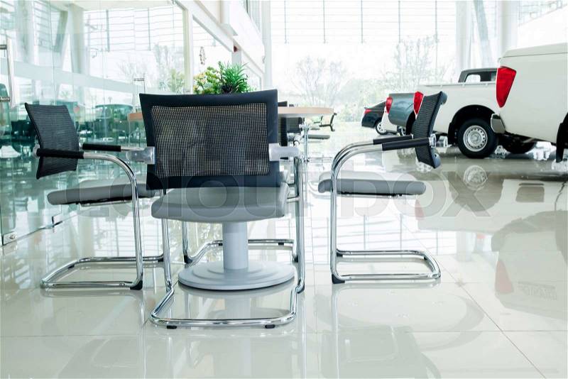 Inside car showroom interior with group of chairs and table for discussion, stock photo
