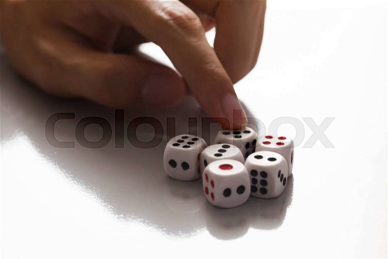 Human hand ready to roll the dice in very dark tone against the light - Try luck, Take Risk or Business concept (Focus on dices), stock photo