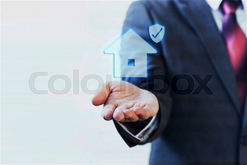 Businessman presenting virtual house with protection on his palm of hand - house insurance concept, stock photo