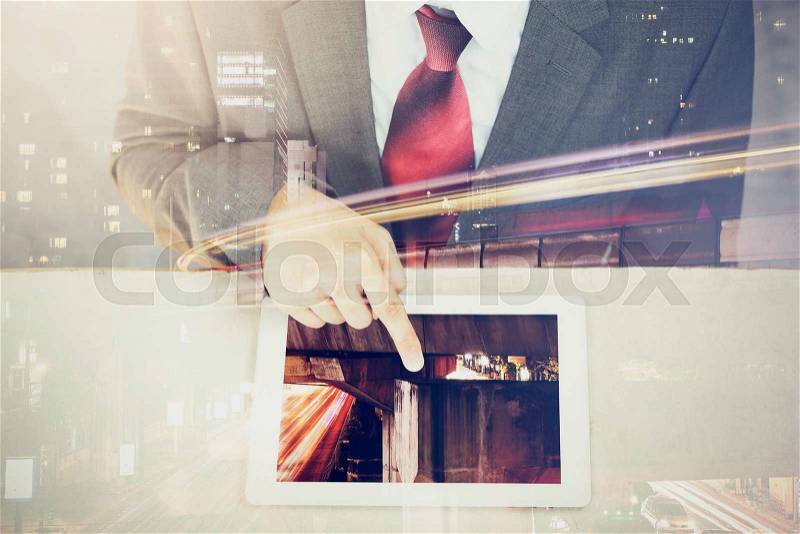 Double Exposure of Businessman touching a tablet in long exposure city scene, stock photo