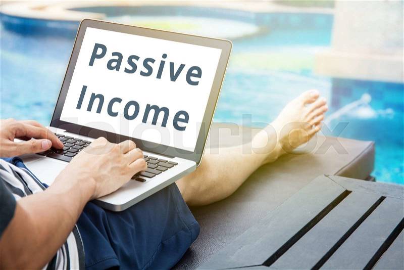 \'Passive Income\' word on man relaxing with his laptop, stock photo