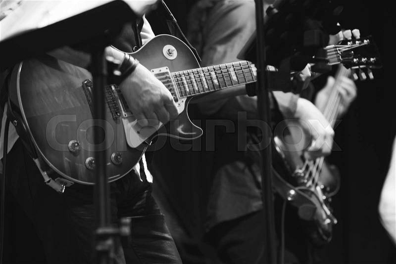 Rock and roll music background, guitar players on a stage, selective focus, stock photo
