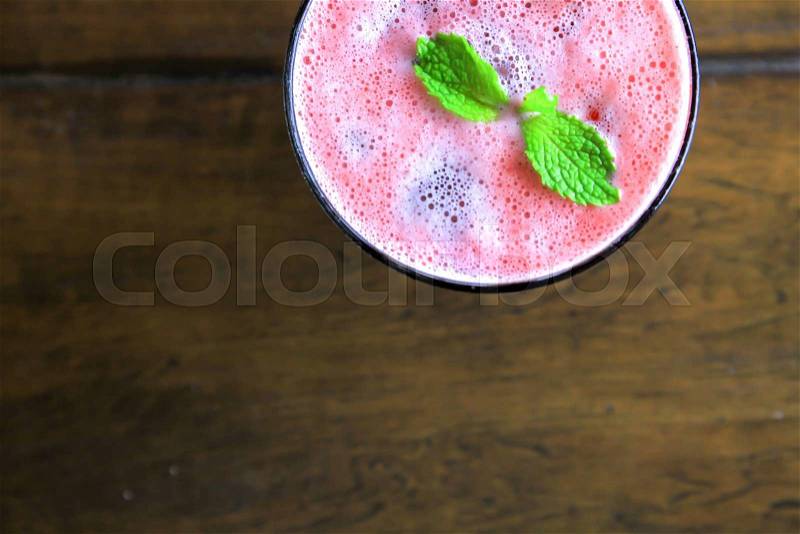 Top view of pink and red smoothie over wooden background with copy space, stock photo