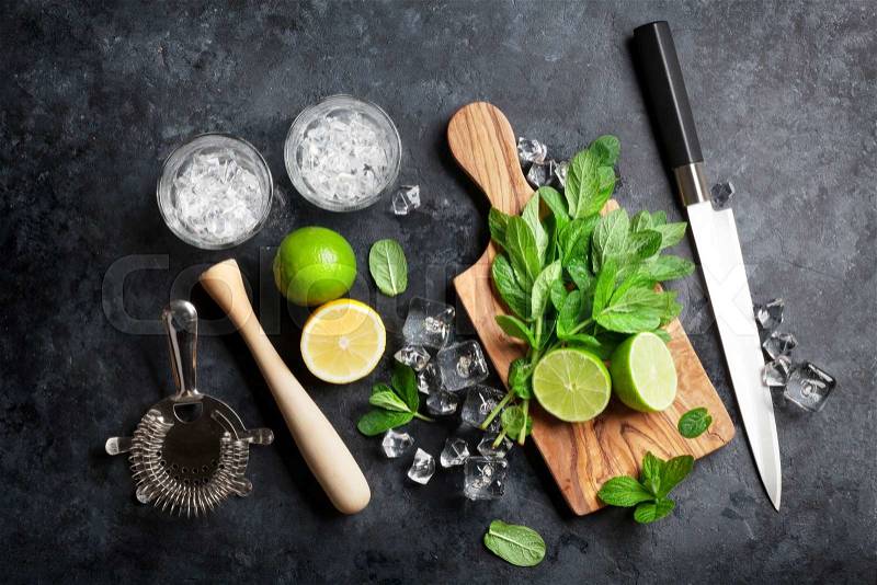 Mojito cocktail making. Mint, lime, ice ingredients and bar utensils. Top view, stock photo
