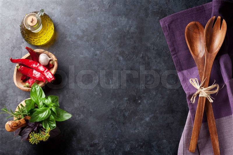 Fresh garden herbs in mortar, chili pepper and olive oil on stone table. Basil, rosemary, dill. Cooking ingredients. Top view with copy space, stock photo