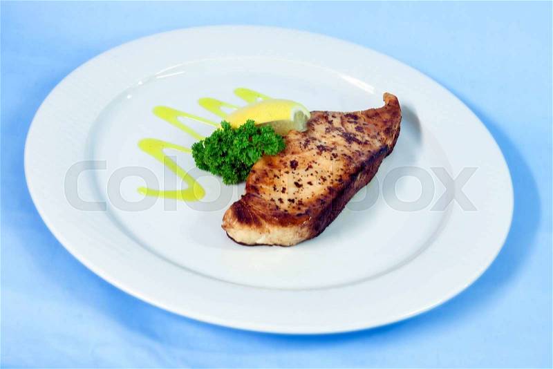 Modern food on a white plate and blue background - grilled salmon with lemon, stock photo