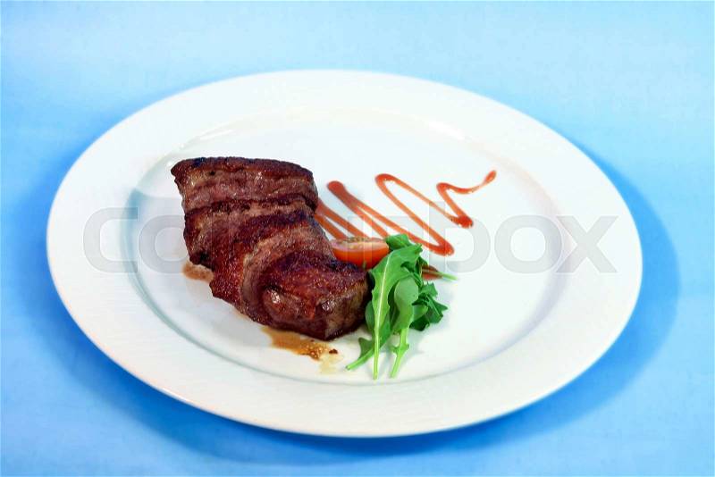 Modern food on a white plate and blue background - grilled duck breast with wine sauce, stock photo