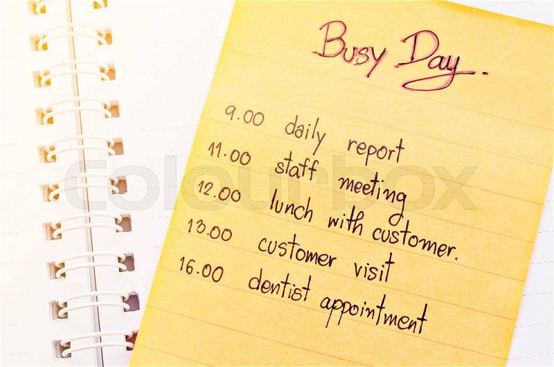 Busy day appointment business schedule in note paper on open diary, stock photo