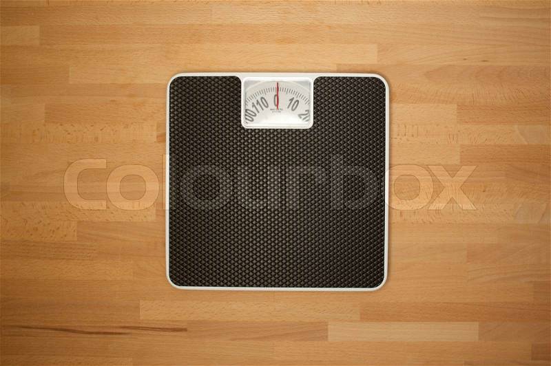Body bathroom scales on a wooden floor, stock photo