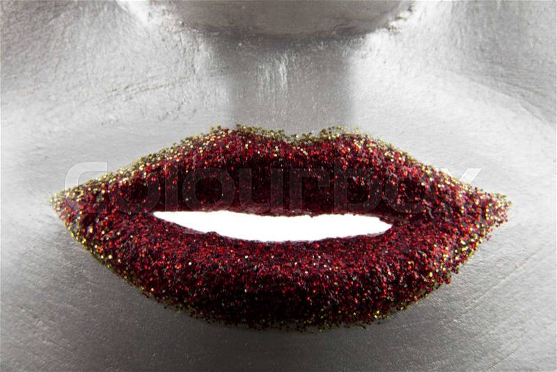 Red lips in glitter on the gray mask closeup, stock photo