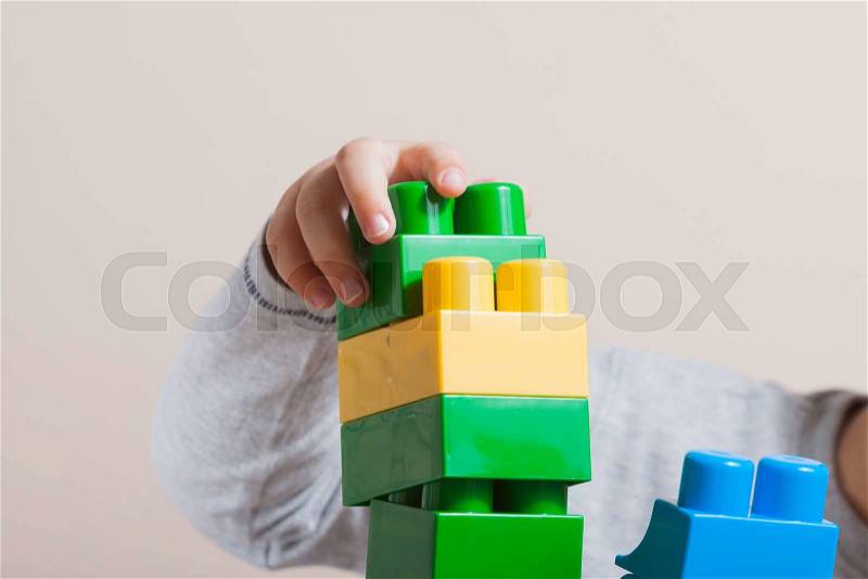Playing little boy with colored cubes, stock photo