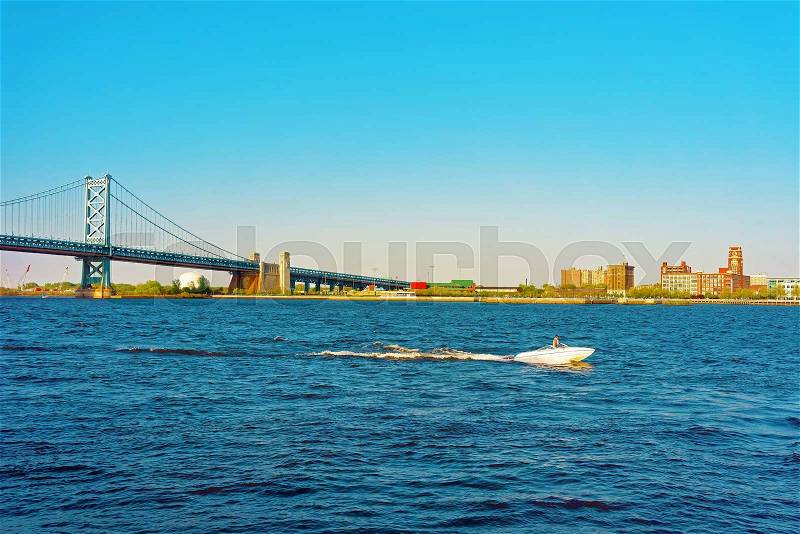 Jet Boat at Benjamin Franklin Bridge over Delaware River in Philadelphia, Pennsylvania, the USA, stock photo