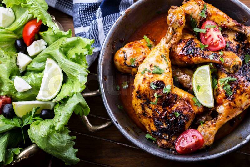 Grilled chicken legs, lettuce and cherry tomatoes limet olives. Traditional cuisine. Mediterranean cuisine, stock photo
