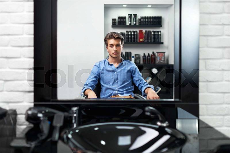 A man looks at himself in the mirror Barbershop, stock photo