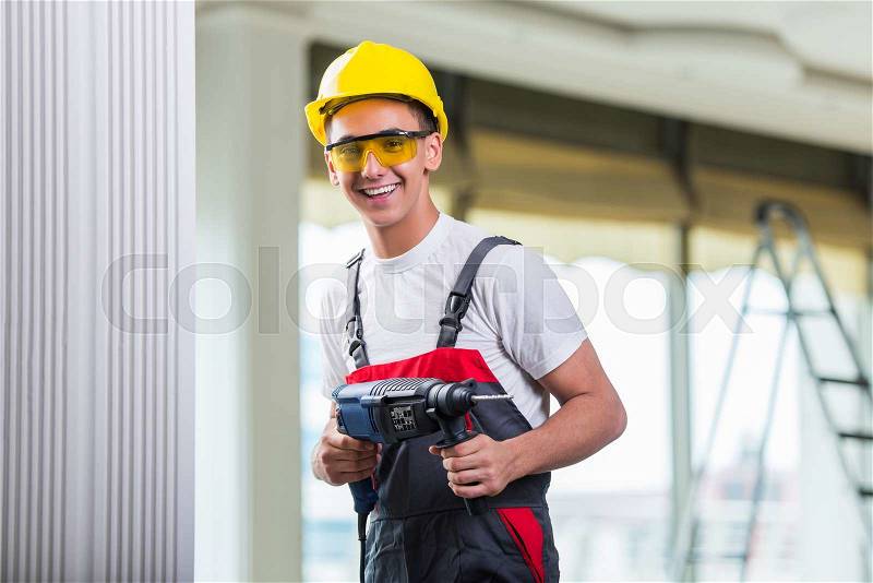 Man drilling the wall with drill perforator, stock photo