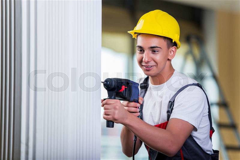 Man drilling the wall with drill perforator, stock photo
