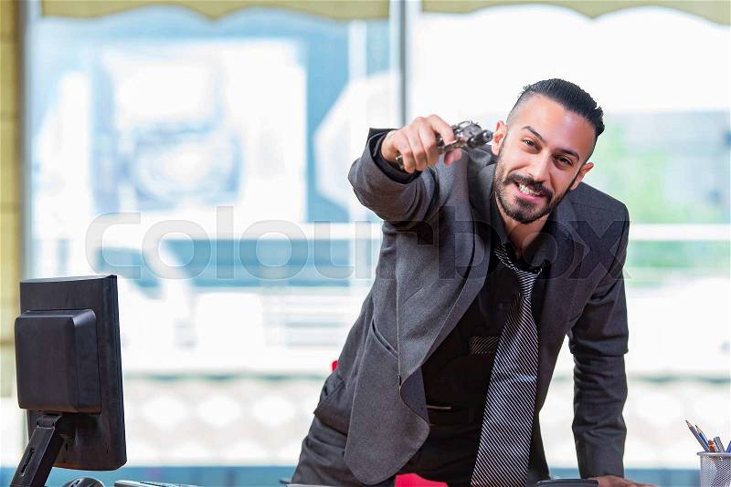 Angry aggressive businessman with gun in the office, stock photo