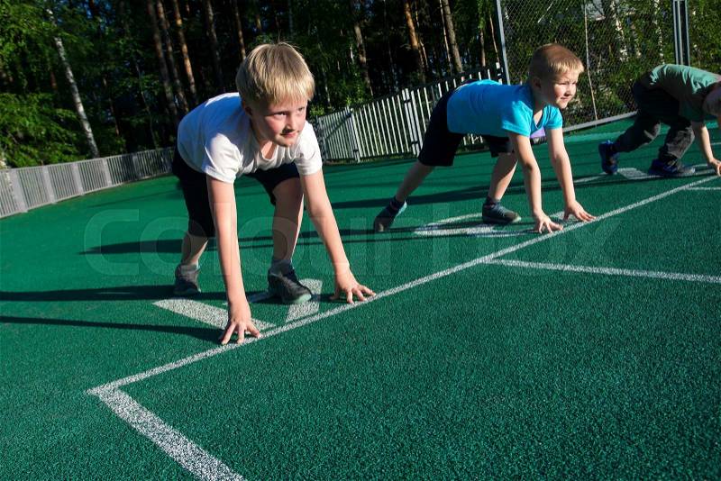 Sports boys (children) on starting position ready to run. Children\'s sports, stock photo