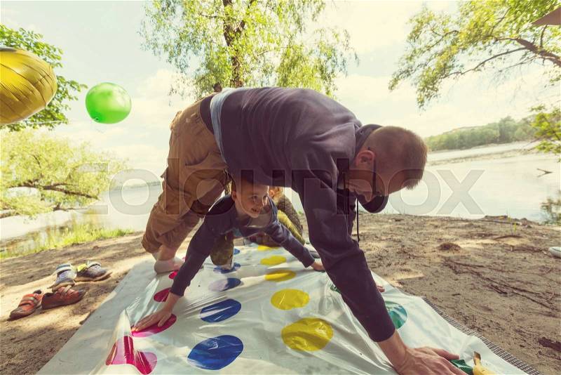 Kids playing twister game outdoors, stock photo