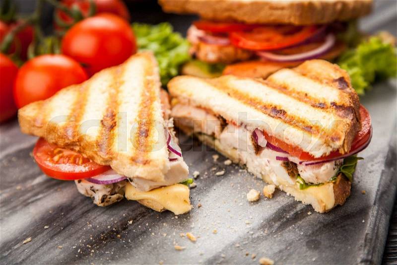 Grilled chicken sandwich with yellow cheese and vegetables, stock photo