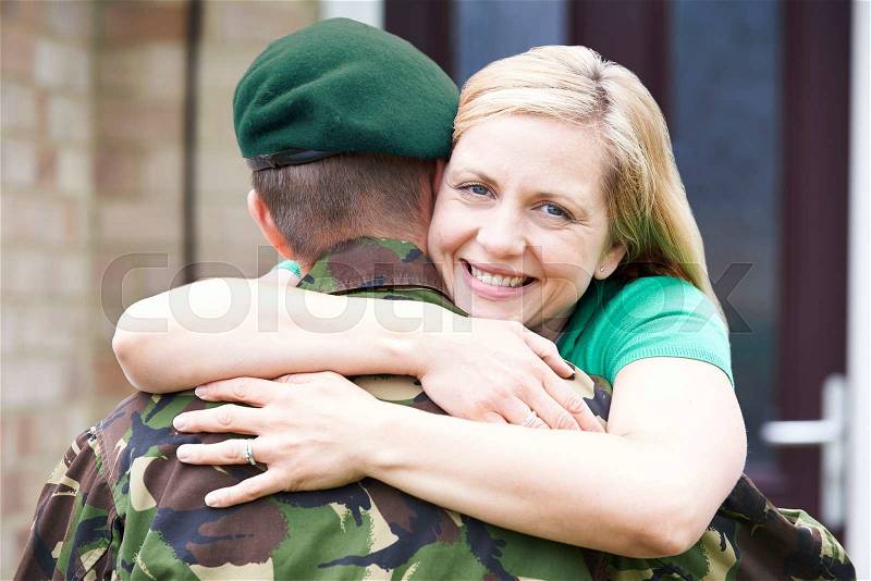 Portrait Of Wife Hugging Army Husband Home On Leave, stock photo