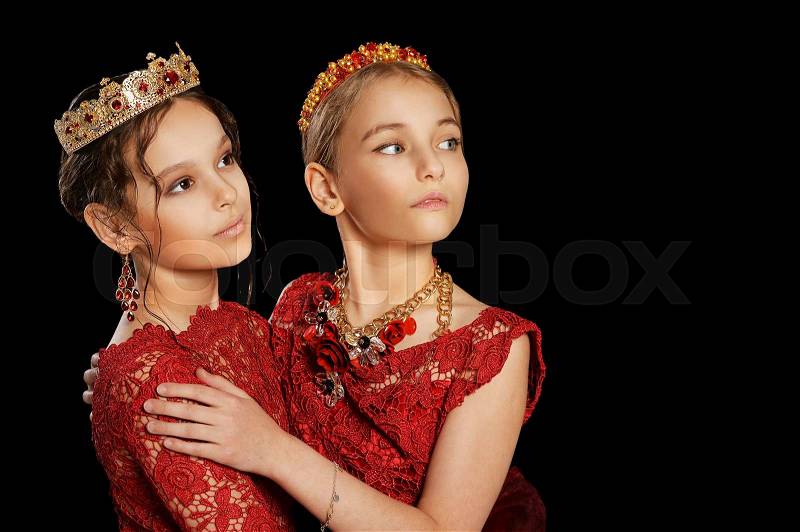 Portrait of beautiful little girls in red dresses on black background, stock photo