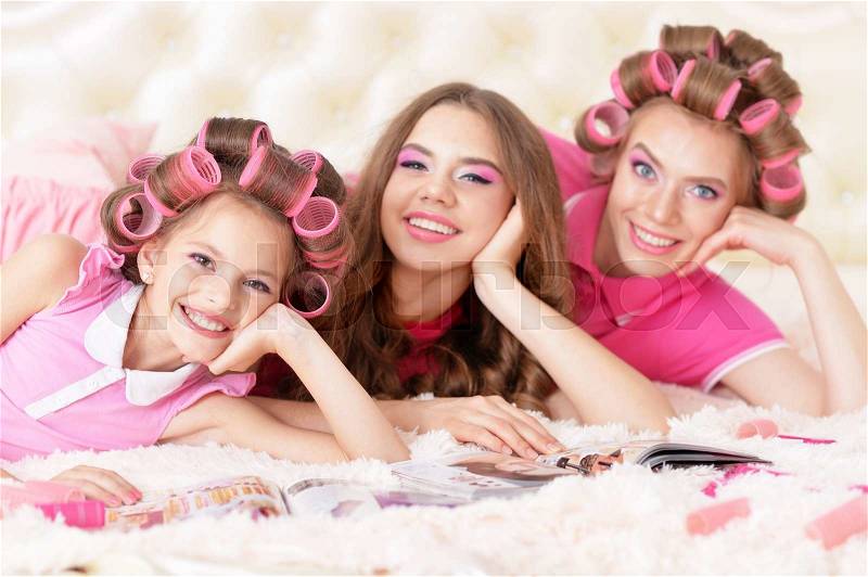 Portrait of happy Mother and daughters in hair curlers at home, stock photo