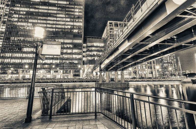 Canary Wharf skyline from street level at night, London UK, stock photo