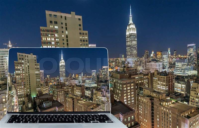 Viewing Manhattan skyline at night on computer screen, stock photo
