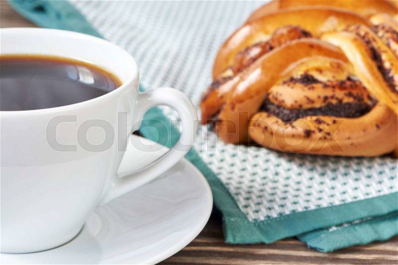 Cup of black coffee and poppy seed cake on napkin, stock photo