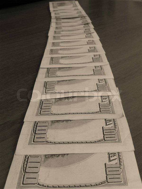 On a photo denominations of 100 dollars a line are laid out. Denominations lay on a table. A photo in brown tones. The photo is made in Ukraine, stock photo