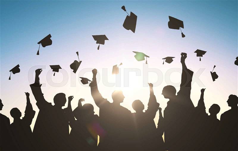 Education, graduation and people concept - silhouettes of many happy students in gowns throwing mortarboards in air, stock photo